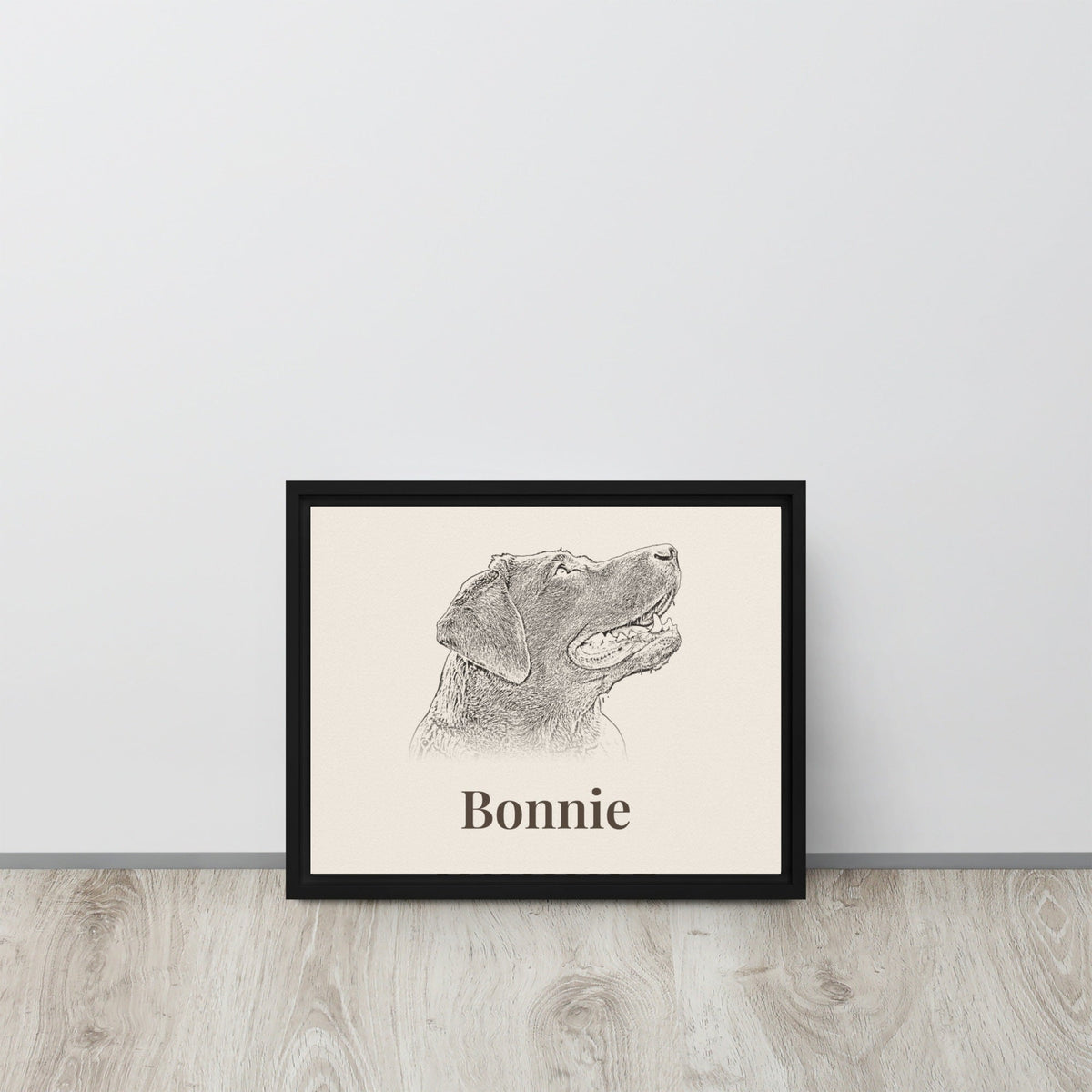 Personalised pencil sketch dog portrait in black framed canvas leaning against a wall