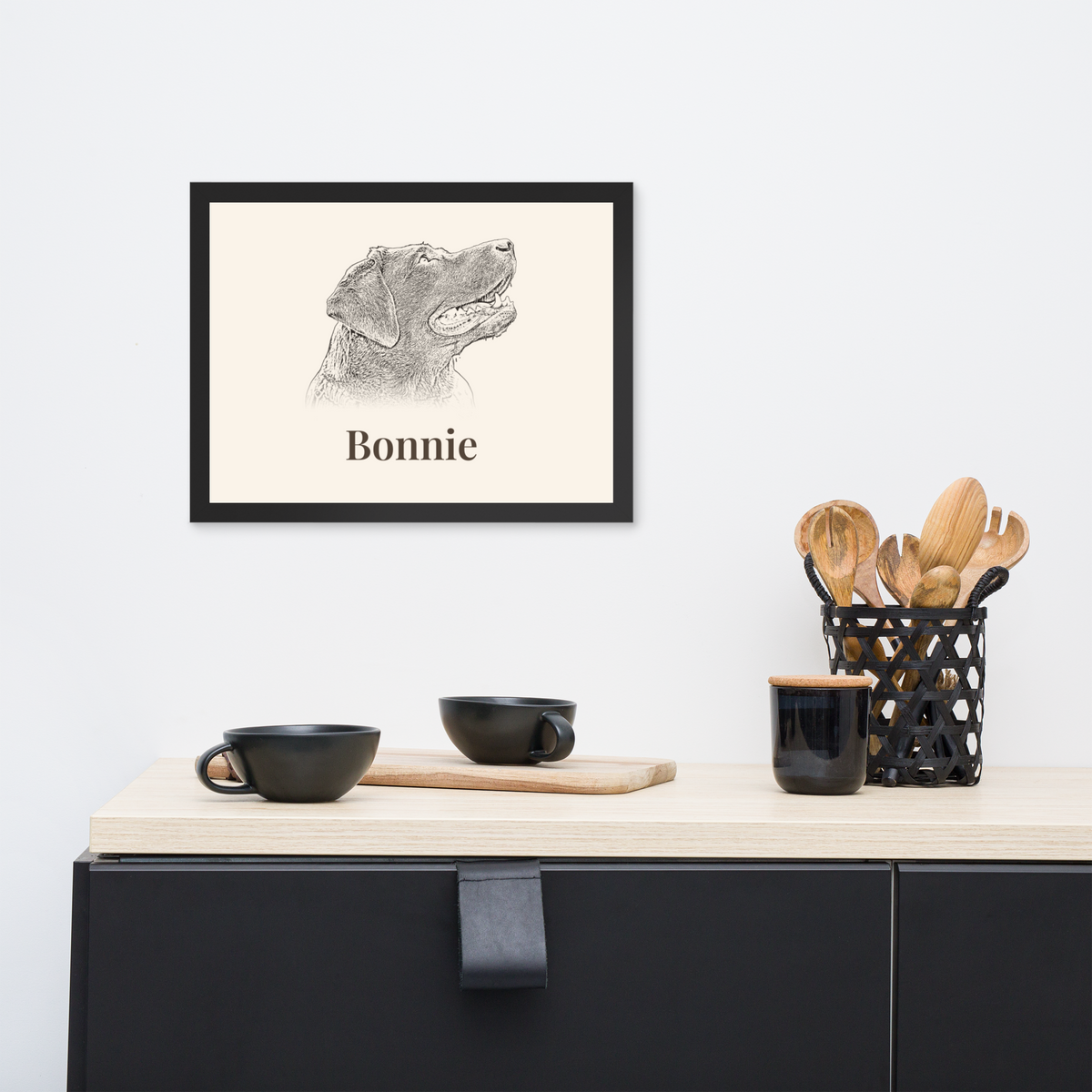 Black framed 30x40cm pet portrait print on a wall above a sideboard