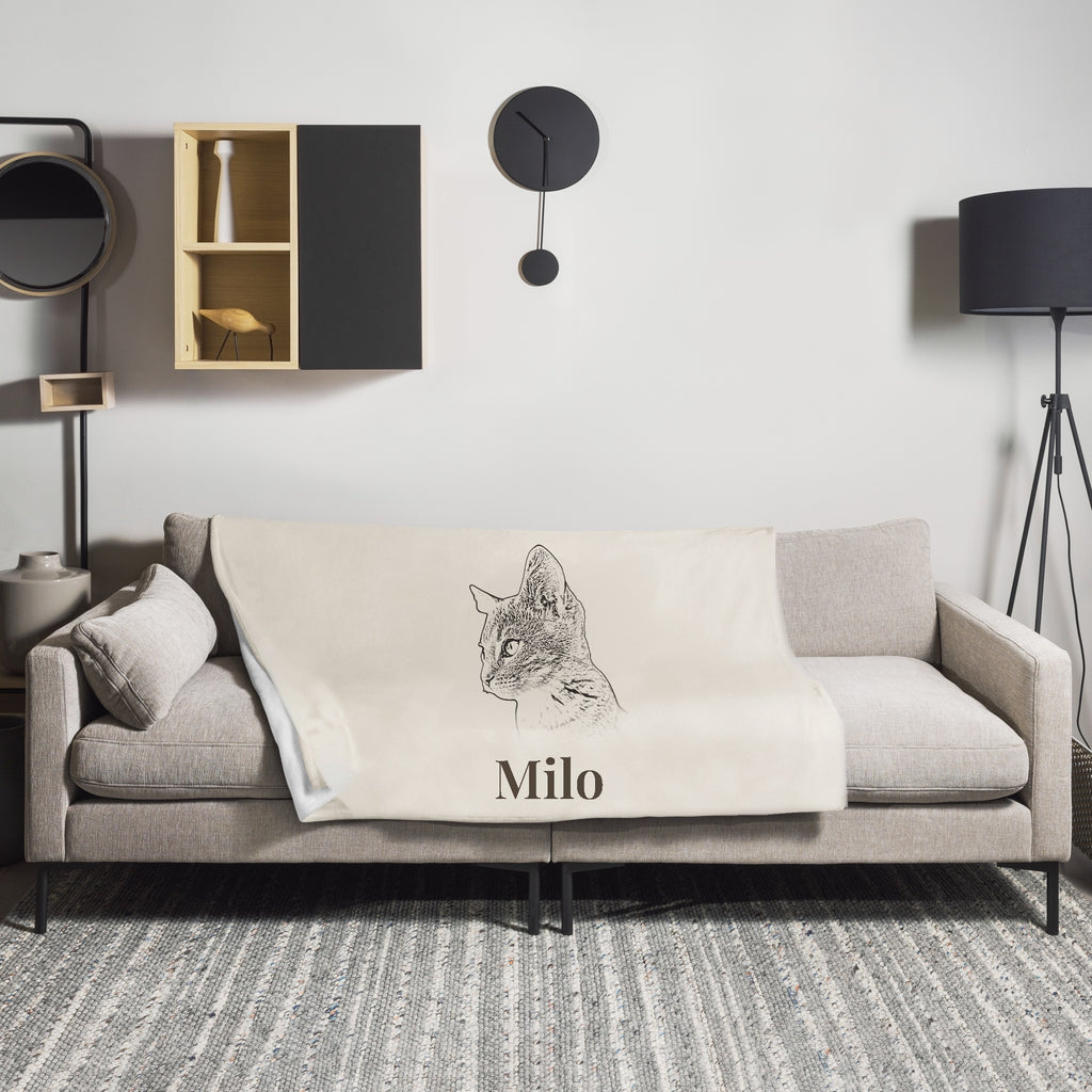 Personalised cat portrait blanket named Milo on a sofa