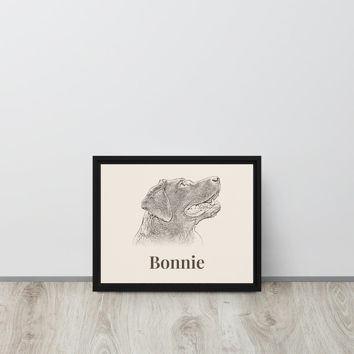 Personalised pencil sketch dog portrait in black framed canvas leaning against a wall