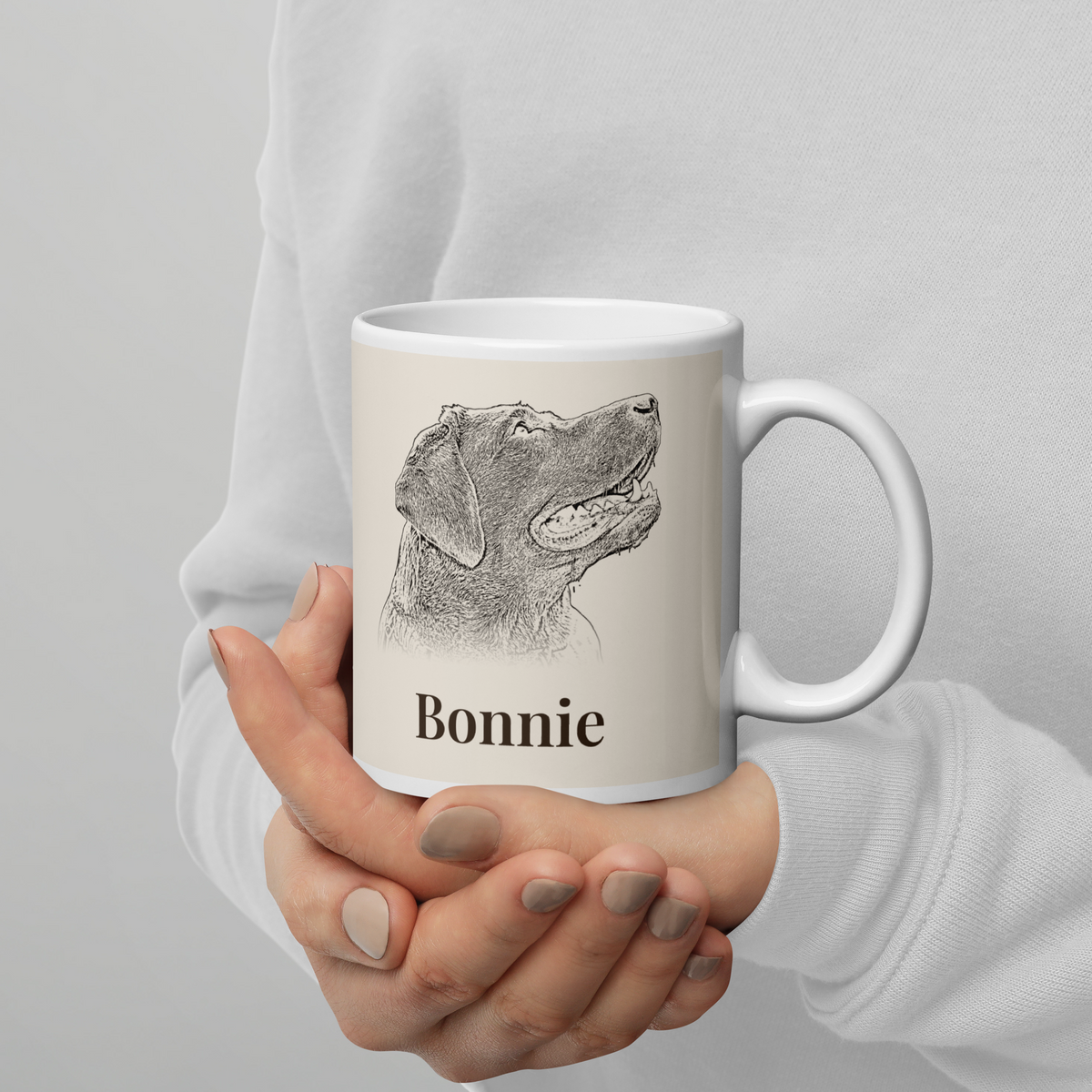 Hands holding a white 11oz mug with a sketched Labrador portrait