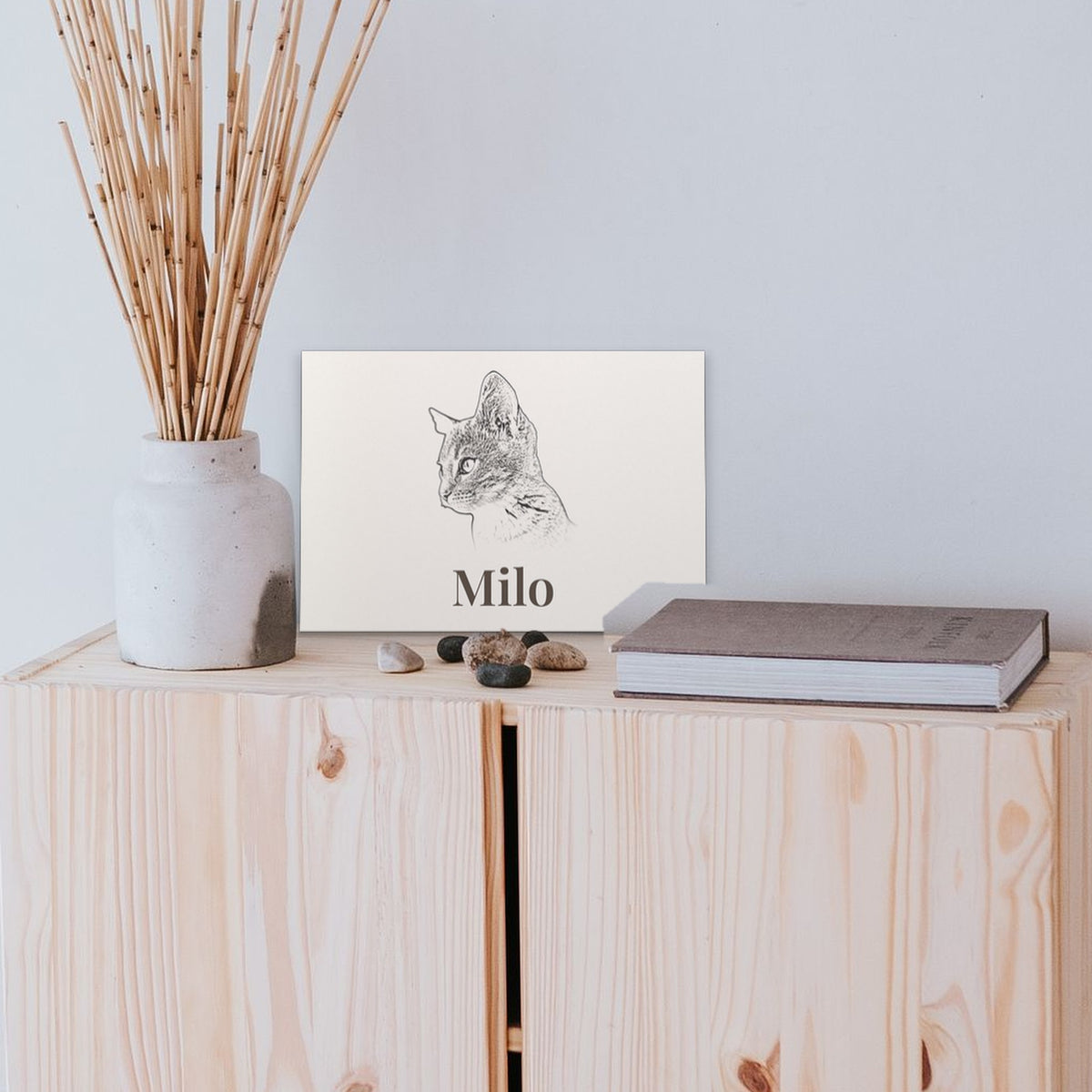 Personalised unframed cat portrait print named Milo on a cabinet